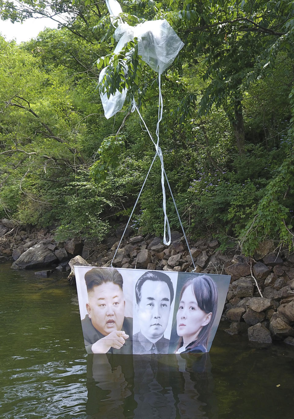 A balloon carrying a banner with images of North Korean leader Kim Jong Un, left, the late leader Kim Il Sung, center, and Kim Yo Jong, the powerful sister of Kim Jong Un, released by Fighters For Free North Korea, is seen in Hongcheon, South Korea, Tuesday, June 23, 2020. A South Korean activist said Tuesday hundreds of thousands of leaflets had been launched by balloon across the border with North Korea overnight, after the North repeatedly warned it would retaliate against such actions. (Yang Ji-woong/Yonhap via AP)