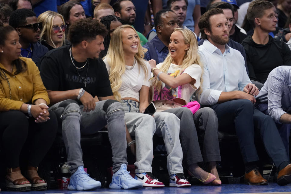 Olympic gymnast Nastia Liukin, second from right, jokes with Kansas City Chiefs quarterback Patrick Mahomes, second from left and his wife, Brittany Matthews, center, during the second half of Game 5 of an NBA basketball first-round playoff series, Monday, April 25, 2022, in Dallas. (AP Photo/Tony Gutierrez)