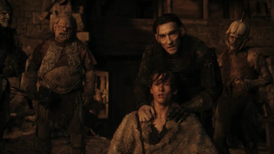 Adar holds a human boy for sacrifice in front of some orcs on The Rings of Power