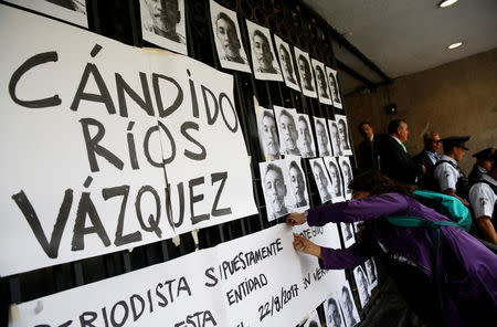 A journalist places posters and pictures of reporter Candido Rios, who was killed in Veracruz, during a demonstration against his killing, at the Interior Ministry building in Mexico City, Mexico August 24, 2017. REUTERS/Henry Romero