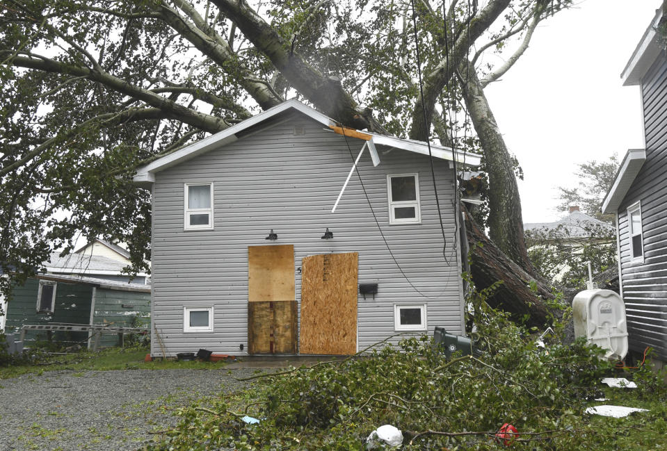 Fallen trees lay on a house in Glace Bay, Nova Scotia, on Sunday, Sept. 25, 2022. A day after post-tropical storm Fiona left a trail of destruction through Atlantic Canada and eastern Quebec, residents of a coastal town in western Newfoundland continued to pick through wreckage strewn across their community, easily the most damaged area in the region. (Vaughan Merchant/The Canadian Press via AP)