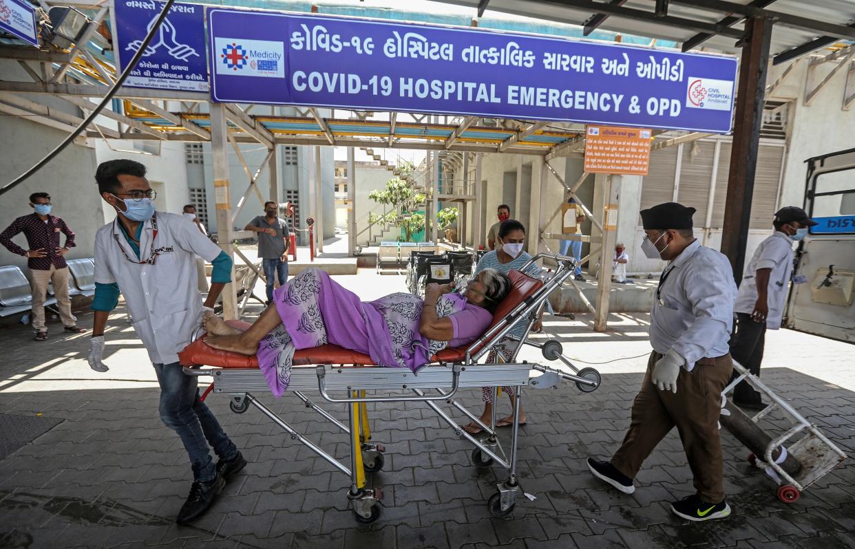Indian health workers bring a suspected Covid-19 positive patient into a hospital in Ahmedabad, India (EPA)