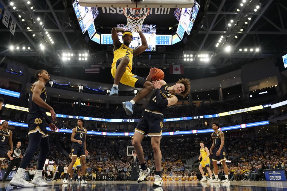 Marquette's Chase Ross dunks over Notre Dame's Braeden Shrewsberry during the first half of an NCAA college basketball game Saturday, Dec. 9, 2023, in Milwaukee. (AP Photo/Morry Gash)