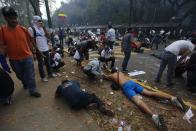 Manifestantes yacen sobre el piso durante una protesta antigubernamental en Caracas, Venezuela, el miércoles 12 de marzo de 2014. (AP Photo/Fernando Llano)