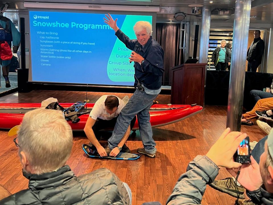 Snowshoe leader March demonstrates how to use the boots.