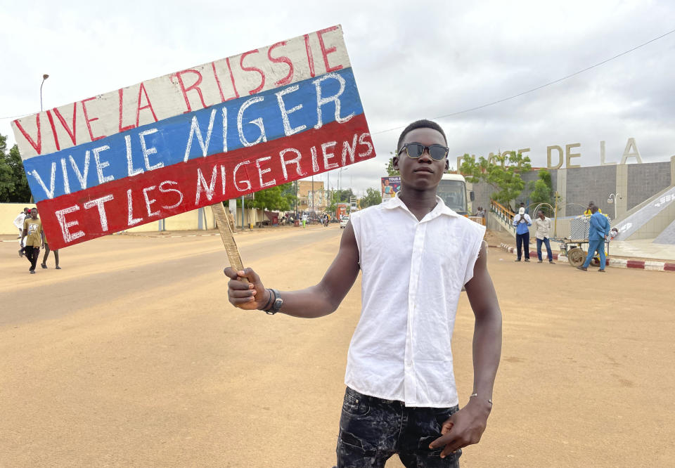 A supporter of Niger's ruling junta holds a placard in the colors of the Russian flag reading "Long Live Russia, Long Live Niger and Nigeriens" at the start of a protest called to fight for the country's freedom and push back against foreign interference in Niamey, Niger, Thursday, Aug. 3, 2023. The march falls on the West African nation's independence day from its former colonial ruler, France, and as anti-French sentiment spikes, more than one week after mutinous soldiers ousted the country's democratically elected president. (AP Photo/Sam Mednick)