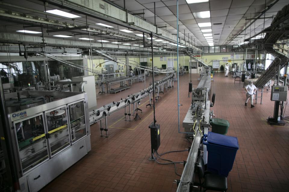 The assembly room is almost empty at the Santa Teresa rum factory while under 10 percent of workers are on duty, due to the new coronavirus in La Victoria, Aragua state, Venezuela, Wednesday, April 1, 2020. Venezuela's premier rum distillery and one of Venezuela's few private businesses says that most of its production will be for antiseptic alcohol, in an effort to help contain the spread of COVID-19. (AP Photo/Ariana Cubillos)