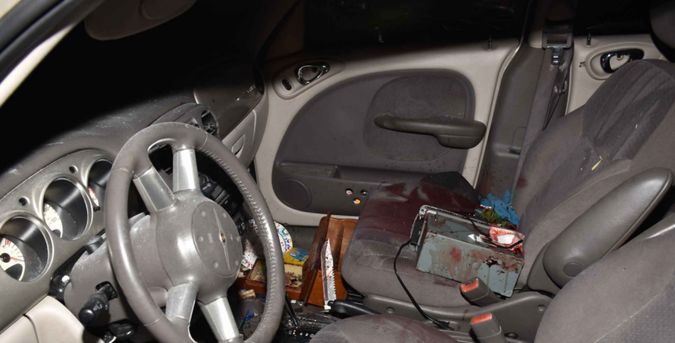 This is a crime scene photo of front interior of the Chrysler PT Cruiser that Daniel Palato had just been shot and killed in by Clay County deputies on April 27, 2022. A knife can be seen to the right of the driver's seat.