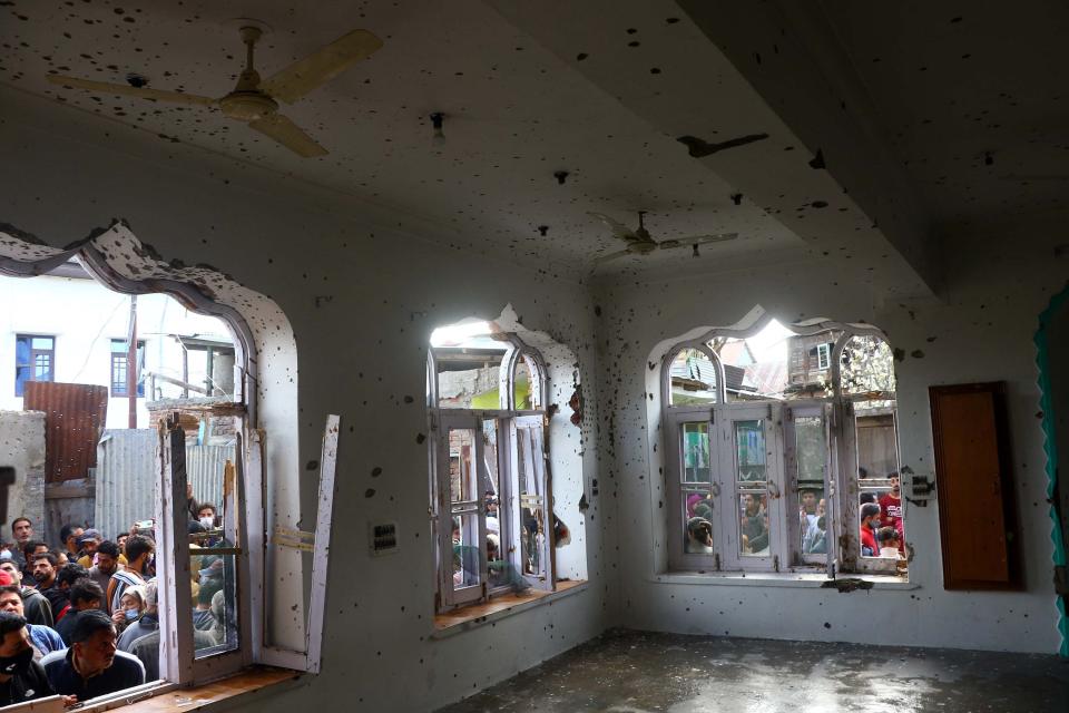 People inspect a mosque partially damaged during a gunbattle between Indian soldiers and suspected militants in Shopian.