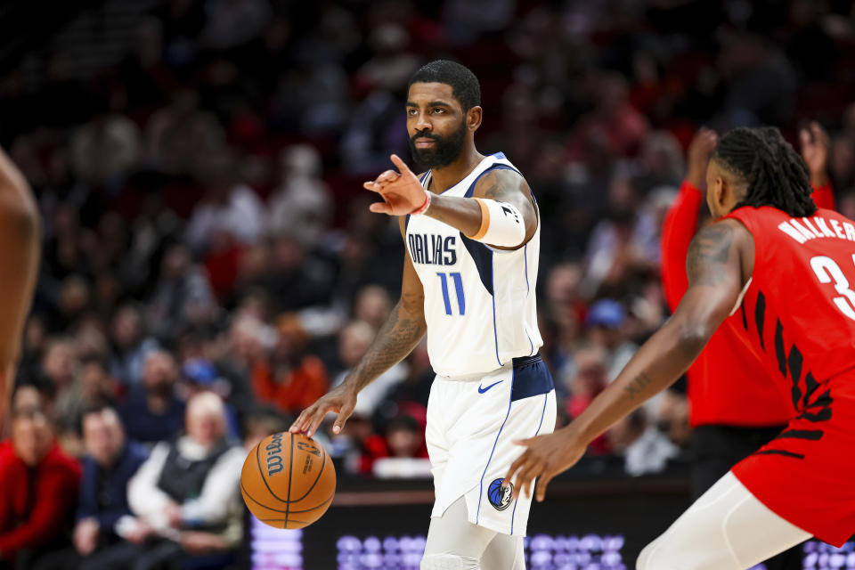 Dallas Mavericks guard Kyrie Irving gestures to teammates during the first half of their NBA basketball game against the Portland Trail Blazers on Friday, Dec. 8, 2023, in Portland, Ore. (AP Photo/Howard Lao)
