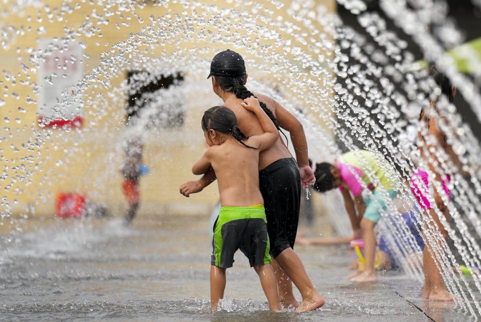 <span class="caption">Mississaugas of the New Credit First Nation children play in water sprinklers during National Indigenous Peoples Day celebrations in Mississauga, Ont., on June 21, 2022. </span> <span class="attribution"><span class="source">THE CANADIAN PRESS/Nathan Denette</span></span>