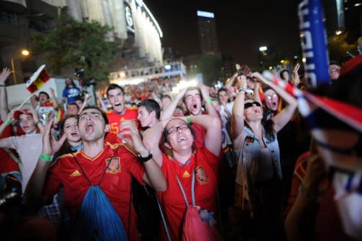 Supporters of the Spanish national football team react as they watch the Euro 2012 Championships football match between Spain and Portugal on a giant screen near the Santiago Bernabeu Stadium in Madrid. Defending champions Spain beat Portugal 4-2 on penalties after their Euro 2012 semi-final finished 0-0 after extra-time