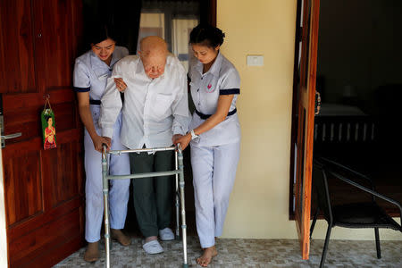 Wolfgang, 96, from Switzerland is helped to walk by two nurses, while staying at the Care Resort in Chiang Mai, Thailand April 6, 2018. Picture taken April 6, 2018. REUTERS/Jorge Silva