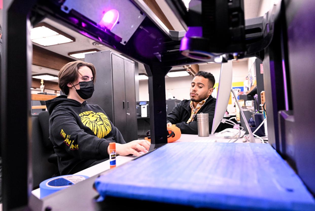 Redwood engineering student Sam Kindschuh, left, and XL Adviser Xico Rojas work with a 3-D printer Tuesday, May 2, 2023. The students have created a prosthetic hand for classmate Tyler Stark so he can throw out the first pitch Tuesday, May 9 against Mt. Whitney.