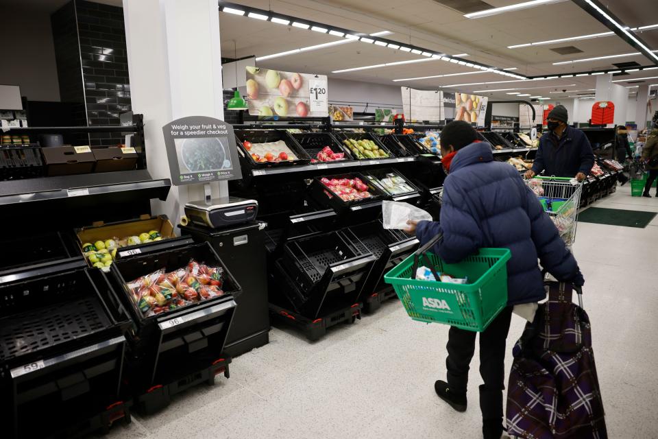 Shoppers wearing a face mask or covering due to the COVID-19 pandemic, look at empty fruit and vegetable troughs inside an ASDA supermarket in Walthamstow in north east London on December 22, 2020. - The British government said Tuesday it was considering tests for truckers as part of talks with French authorities to allow the resumption of freight traffic suspended due to a new strain of coronavirus. Britain was plunged into fresh crisis last week with the emergence of a fresh strain of the virus, which is believed to be up to 70 percent more transmissible than other forms. (Photo by Tolga Akmen / AFP) (Photo by TOLGA AKMEN/AFP via Getty Images)