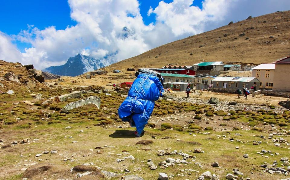 Ο Sherpa Porter μεταφέρει ένα βαρύ φορτίο στο Everest Base Camp