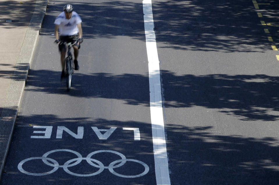 A cyclist takes advantage of an empty Olympic Lane on the embankment in central London, Monday, July 23, 2012. The Olympic road lanes will come into effect on Wednesday, July 25, two days before the Opening ceremony of the 2012 Summer Olympics. Only accredited vehicles will be allowed to use them. London's traditional taxis will not be allowed in them. (AP Photo/Kirsty Wigglesworth)