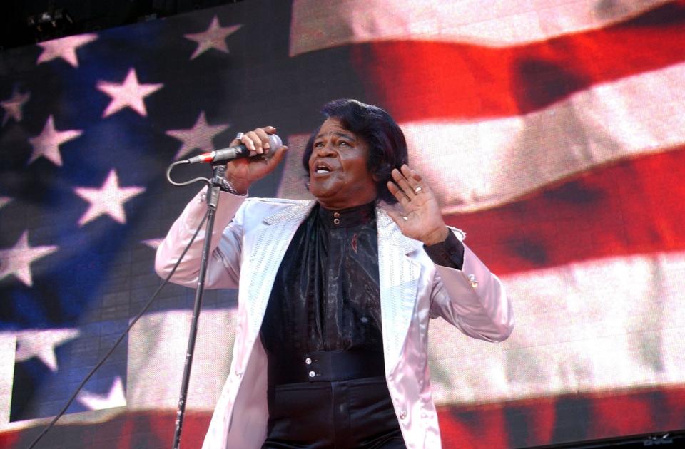 James Brown standing in front of an American flag.