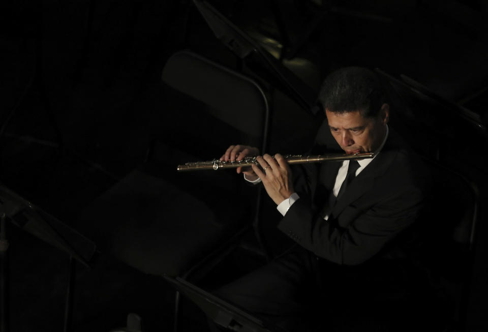 A man plays the flute during a homage for Mexican crooner Jose Jose at the Palace of Fine Arts in Mexico City, Wednesday, Oct. 9, 2019. Jose Jose died Sept. 28 in South Florida. His body was cremated in Miami and it was agreed after a dispute among relatives that half the ashes would remain there and the other half would be brought to Mexico. (AP Photo/Fernando Llano)