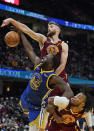 Cleveland Cavaliers' Dean Wade, top to bottom, Golden State Warriors' Draymond Green and Darius Garland battle for a rebound in the second half of an NBA basketball game, Thursday, Nov. 18, 2021, in Cleveland. The Warriors won 104-89. (AP Photo/Tony Dejak)