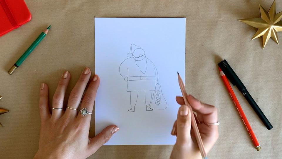 a person's hands above a drawing of santa