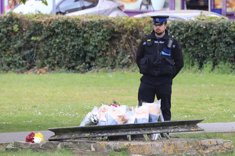 A PCSO looks at flowers and messages left in Aylesham, Kent, for PCSO Julia JamesPA