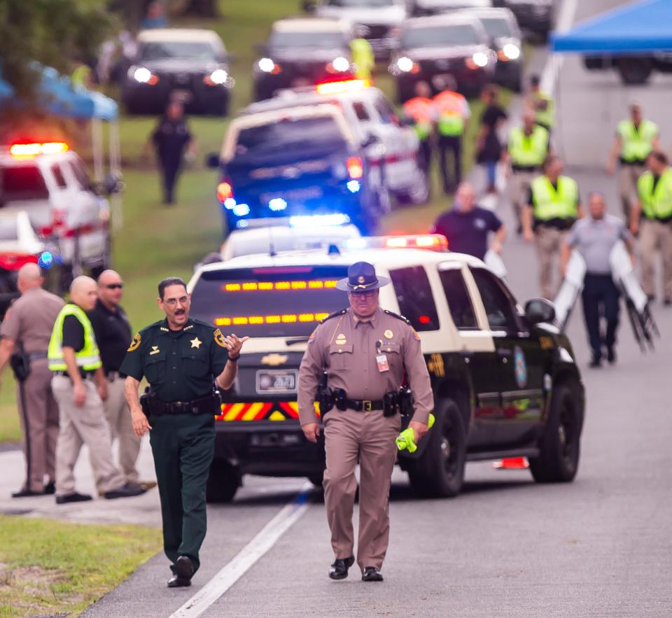 Sheriff Billy Woods, at left in green uniform, gave a press conference Tuesday at the crash site.