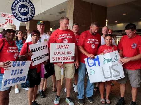 Auto workers from the General Motors Lordstown assembly plant stop to be photographed while protesting GM plant closings outside General Motors World Headquarters in Detroit,