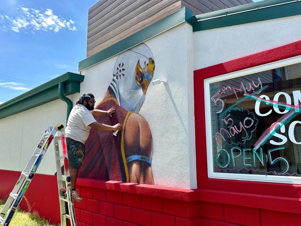 Rodrigo Alvarez paints a luchador onto the side of a new Mexican restaurant in Gardner, which will open on Cinco de Mayo. Jenna Thompson/jthompson@kcstar.com
