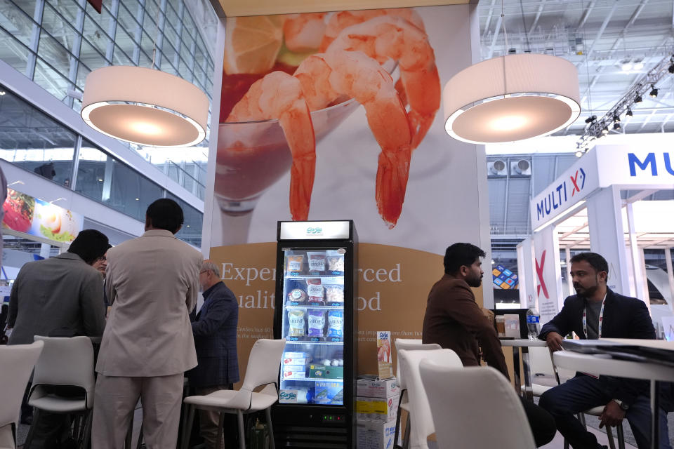 Signs displaying shrimp, top, appear at an exhibit booth for CenSea, a frozen seafood importer, at the North American Seafood Expo, Monday, March 11, 2024, in Boston. U.S. trade records show the Indian company Nekkanti Sea Foods shipped 726 U.S. tons of farmed shrimp from India to the U.S. in the past year, to major American seafood distributors including AJC International Inc., Eastern Fish, CenSea, Jetro Cash & Carry Enterprises, King & Prince Seafood, Red Chamber Co. and Rich Products Corp. Those companies, in turn, sell Indian shrimp under popular brand names including Costar, Good & Gather, Great Value and Mrs. Friday’s at supermarkets, box stores and restaurants across the U.S. (AP Photo/Steven Senne)