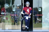 Dallas Cowboys quarterback Dak Prescott (4) walks onto the field followed by offensive coordinator Kellen Moore and practice squad quarterback Ben DiNucci (3) at the team's NFL football training facility in Frisco, Texas, Thursday, Sept. 23, 2021. (AP Photo/Tony Gutierrez)