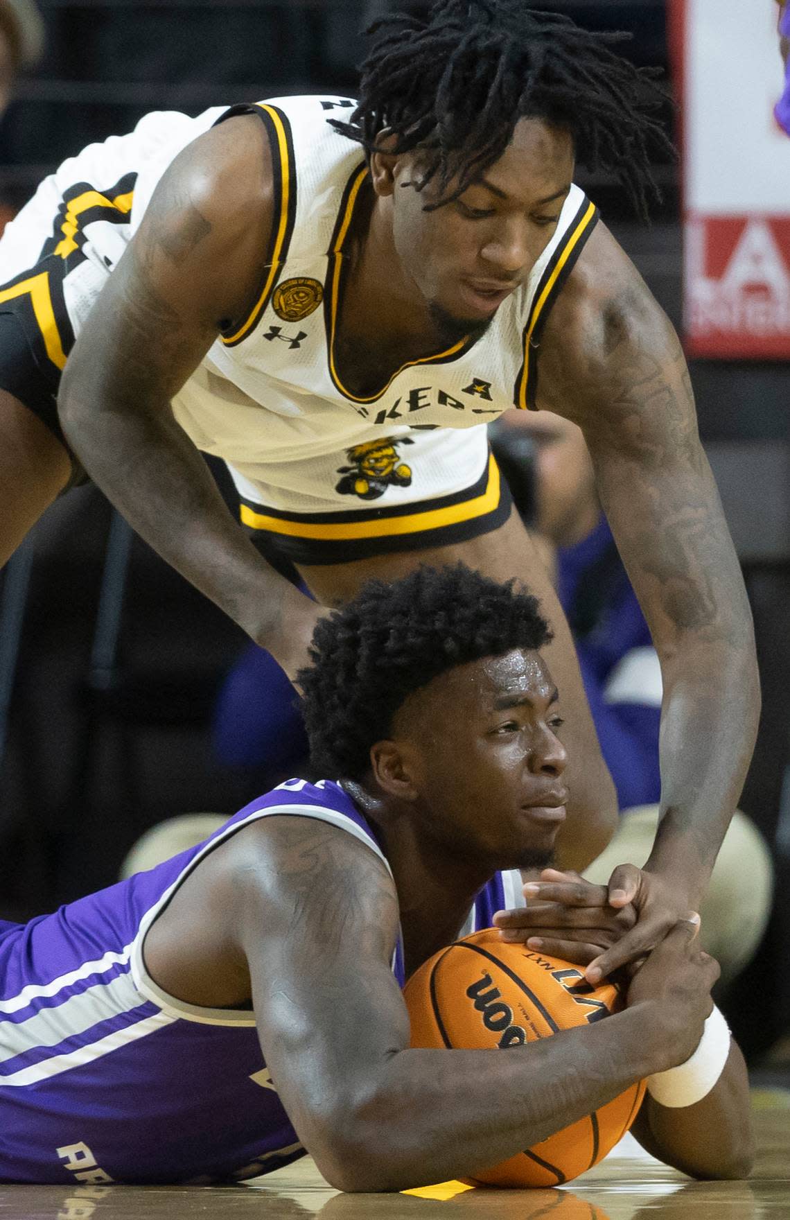 Wichita State’s Jaykwon Walton tries to get a loose ball away from Central Arkansas’ VJ Reeves during the first half of their season-opening game on Monday night.