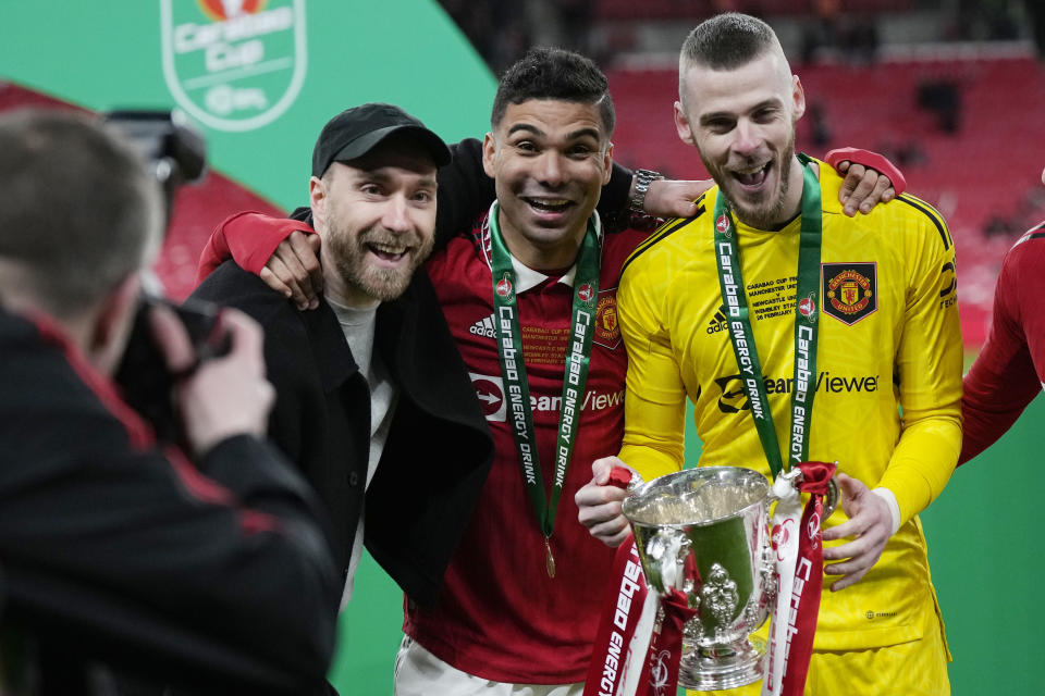 Manchester United's Casemiro, centre, Christian Eriksen, left, and goalkeeper David de Gea pose with the trophy after the English League Cup final soccer match between Manchester United and Newcastle United at Wembley Stadium in London, Sunday, Feb. 26, 2023. (AP Photo/Alastair Grant)