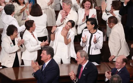 Democratic female members of Congress, including Rep. Alexandria Ocasio-Cortez (D-NY) (C), cheer after President Trump said there are more women in Congress than ever before during his second State of the Union address. REUTERS/Jonathan Ernst