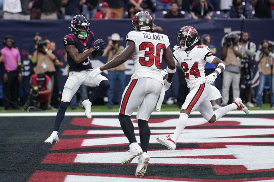 Houston Texans wide receiver Tank Dell, left, makes a touchdown catch in front of Tampa Bay Buccaneers cornerback Dee Delaney (30) and cornerback Carlton Davis III (24) in the final seconds of the second half of an NFL football game, Sunday, Nov. 5, 2023, in Houston. (AP Photo/Eric Gay)