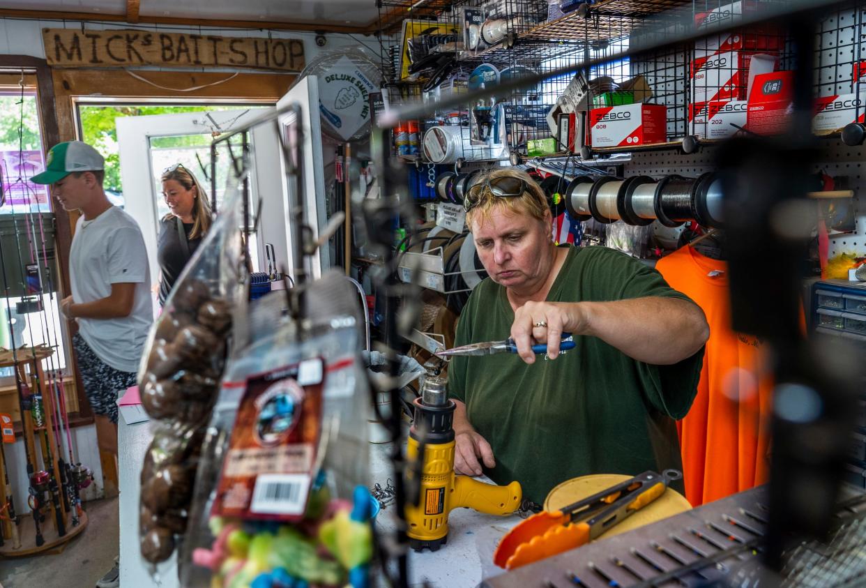 Mick's Bait Shop owner Mick Treiber, 56, heats jigs for her homemade fishing lures inside her shop on Tuesday, July 25, 2023.