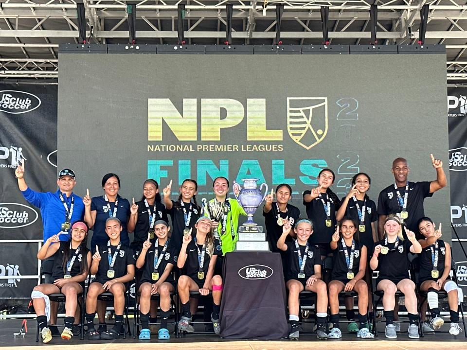 The San Juan South 2009 U14 girls club soccer team poses for a photo alongside its national championship trophy.