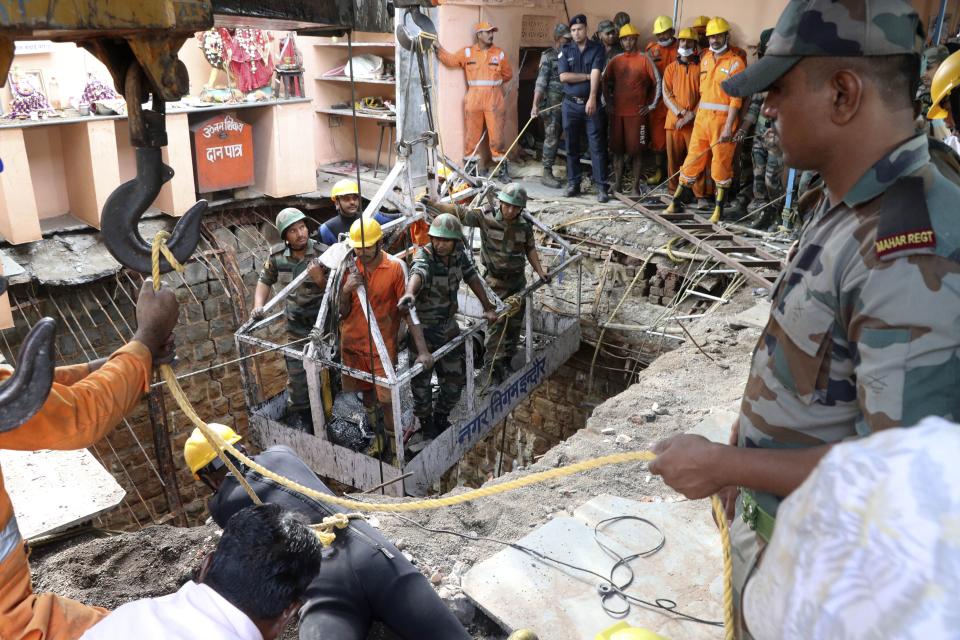Rescuers work at the site of a structure built over an old temple well that collapsed Thursday as a large crowd of devotees gathered for the Ram Navami Hindu festival, in Indore, India, Friday, March 31, 2023.
