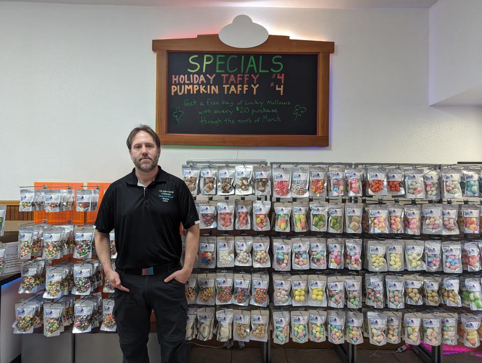 Ice Age Candy Co. owner Shane Blackwell with racks of candy. The shop sells only freeze dried candy and treats.