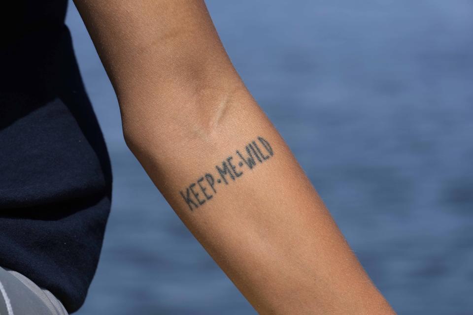 Marine biologist Linda Albonetti displays her tattoo that reads "KEEP ME WILD" on her arm after releasing a turtle named Vulcano back into the Adriatic Sea off the coast of Marina di Ravenna, Italy, Saturday, June 8, 2024. (AP Photo/Luca Bruno)