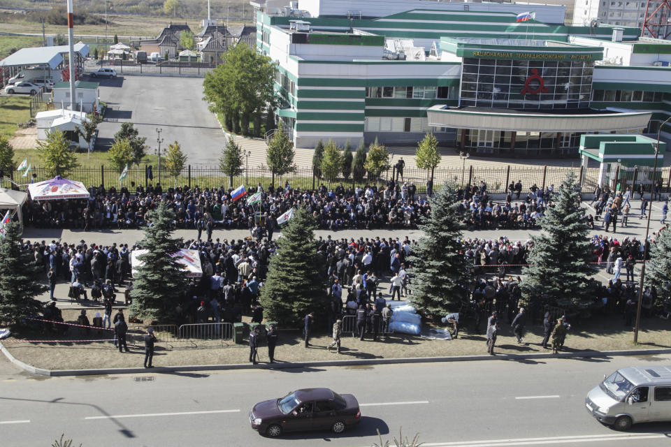 People attend a protest against the new land swap deal agreed by the heads of the Russian regions of Ingushetia and Chechnya, in front of the office of National TV and Radio Company "Ingushetia" in Ingushetia's capital Magas, Russia, Monday, Oct. 8, 2018. Ingushetia and the neighboring province of Chechnya last month signed a deal to exchange what they described as unpopulated plots of agricultural land, but the deal triggered massive protests in Ingushetia where it was seen by many as hurting Ingushetia's interests. (AP Photo/Musa Sadulayev)