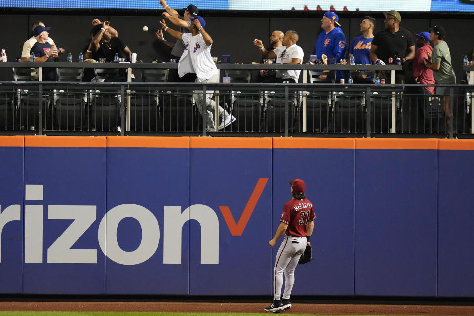 Arizona Diamondbacks center fielder Jake McCarthy watches as fans attempt to catch a ball hit by New York Mets' Mark Vientos for a two-run home run during the sixth inning of a baseball game Wednesday, Sept. 13, 2023, in New York. (AP Photo/Frank Franklin II)