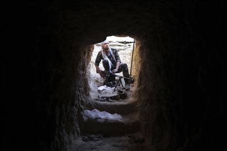 A Free Syrian Army fighter carries his weapon as he takes position inside a tunnel in Deir al-Zor October 15, 2013. Picture taken October 15, 2013. REUTERS/Khalil Ashawi