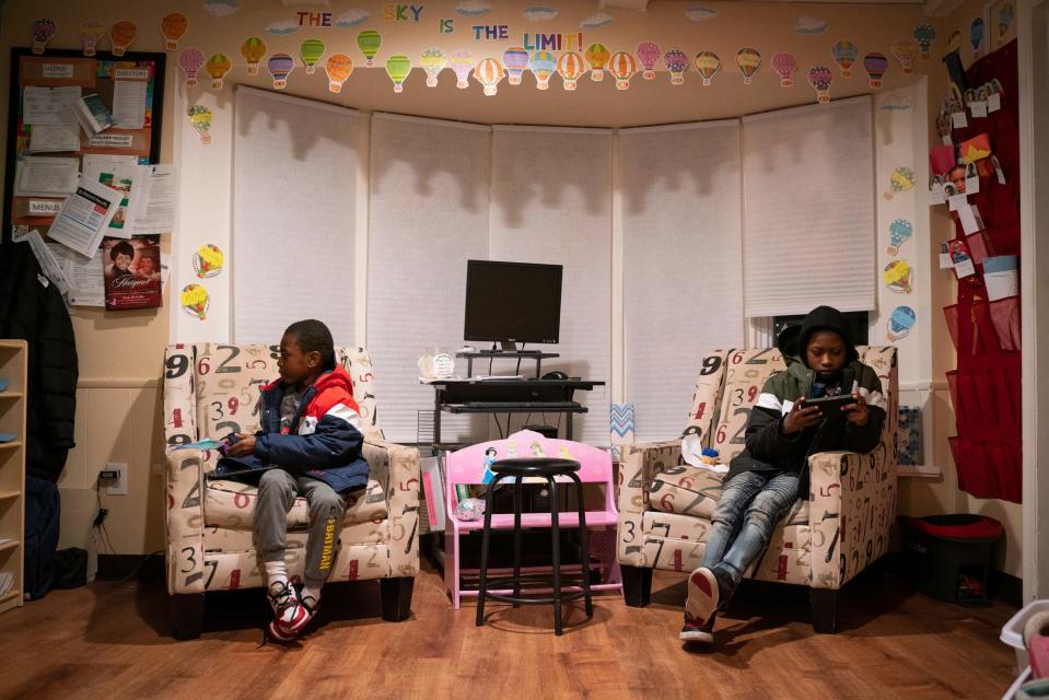 Siblings Thornton Wiley, 6, left, and Tyrone Smith, 10, wait to be picked up during a late night at Angels of Essence Child Care Centre in Detroit on Thursday, Oct. 20, 2022.