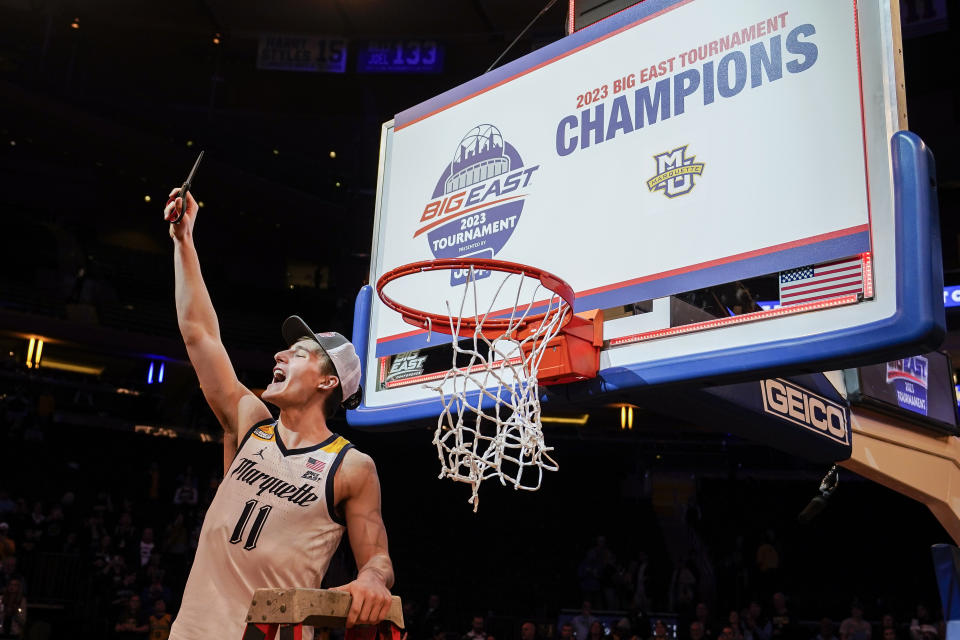 Marquette's Tyler Kolek, tournament MVP, takes a piece of the net after winning their NCAA college basketball game against Xavier for the championship of the Big East men's tournament, Saturday, March 11, 2023, in New York. (AP Photo/John Minchillo)