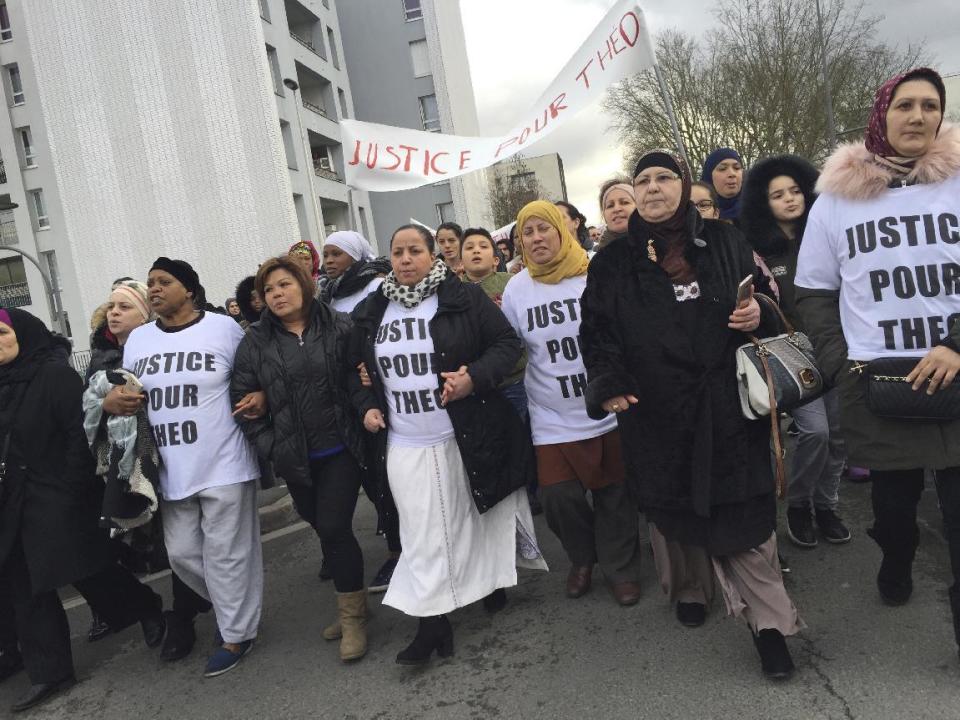 People march in the streets of Aulnay-sous-Bois, north of Paris, holding a sign reading "Justice for Theo" during a protest, a day after a French police officer was charged with the rape of a youth, France, Monday, Feb. 6, 2017. One French police officer has been charged with raping a 22-year-old man and three others have been charged with assault after an identity check degenerated last week in the Paris suburb of Aulnay-sous-Bois. (AP Photo/Milos Krivokapic)