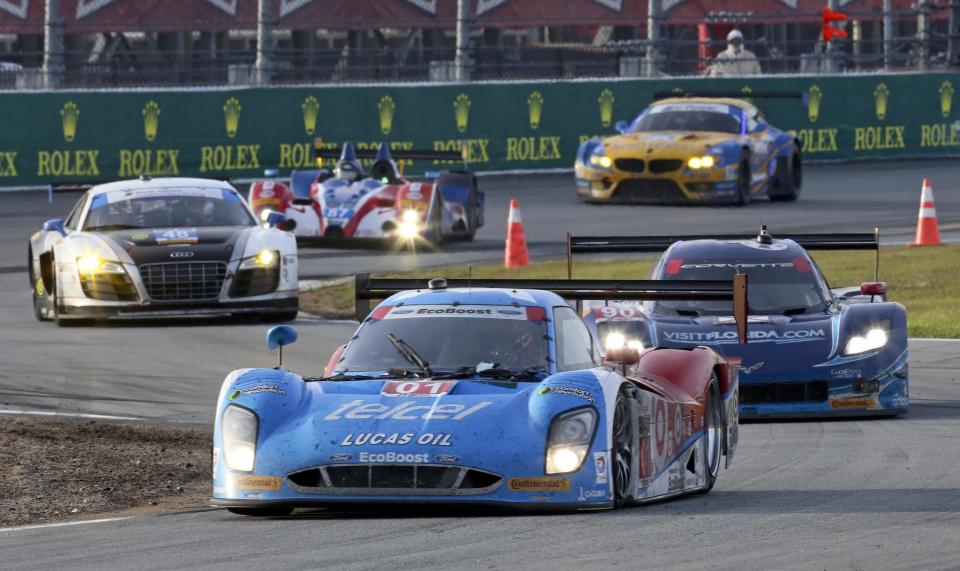 Cars race through the chicane led by the Ganassi Riley DP (01) during the IMSA Series Rolex 24 hour auto race at Daytona International Speedway in Daytona Beach, Fla., Sunday, Jan. 26, 2014.(AP Photo/David Graham)