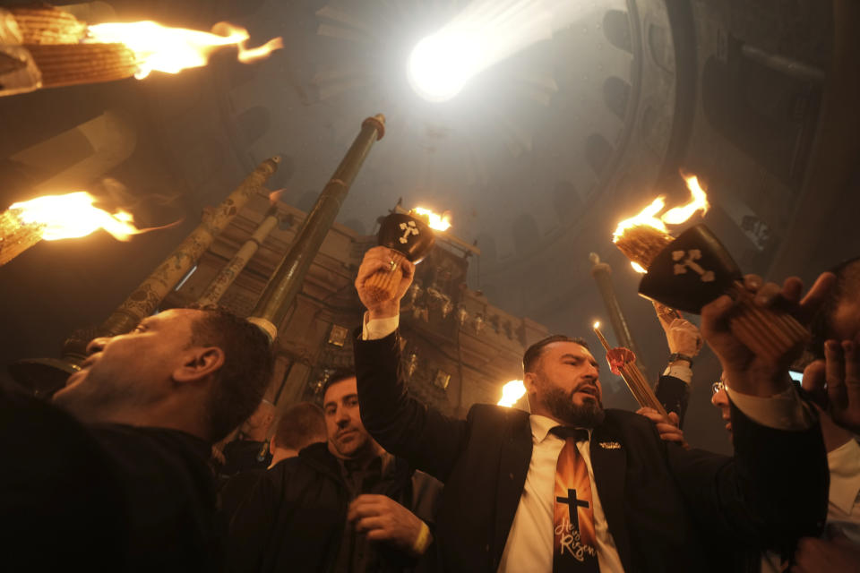 Christian pilgrims hold candles during the Holy Fire ceremony, a day before Easter, at the Church of the Holy Sepulcher, where many Christians believe Jesus was crucified, buried and resurrected, in Jerusalem's Old City, Saturday, April 15, 2023. (AP Photo/Mahmoud Illean)