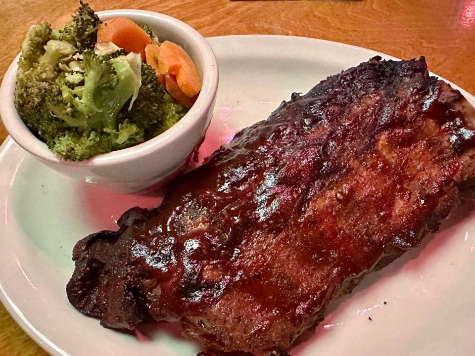 Half rack of ribs at Texas Roadhouse with side of broccoli and sliced carrots