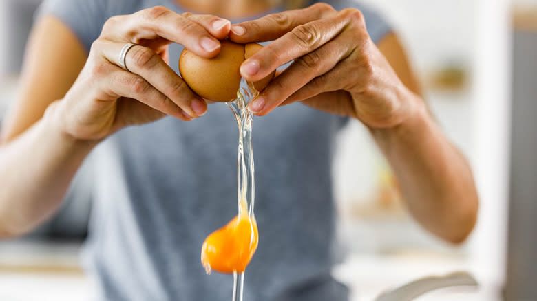Hands cracking an egg 
